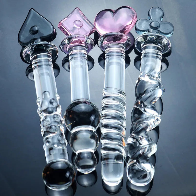 A clear glass dildo with a heart-shaped handle and decorative elements in black, pink, and purple colors.